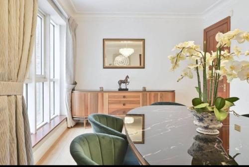a dining room with a table and a vase of flowers at CARLTON COURT - MAYFAIR in London