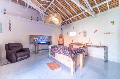 a living room with a couch and a chair at Rainbow Family Bungalow, Your Cozy Base for Sumba Adventures in Lakahembi