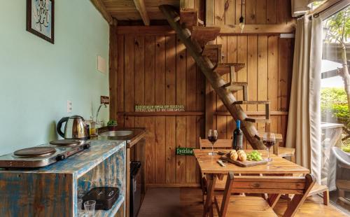 a kitchen with a table and a wooden wall at Moradas do Vale Praia do Rosa in Praia do Rosa