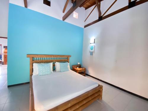 a bedroom with a bed with a blue wall at Hacienda Siete Sentidos in La Mesa