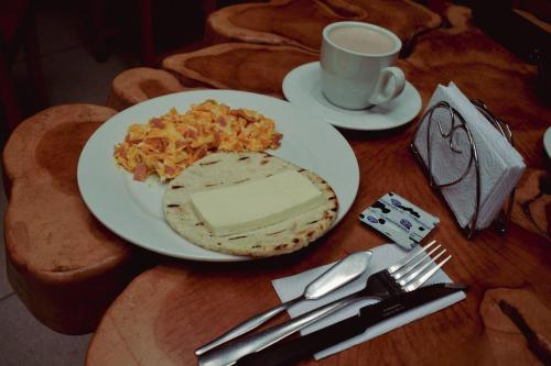 een tafel met een bord eten en een kopje koffie bij Hotel Boutique Sagrado Corazon in Abejorral