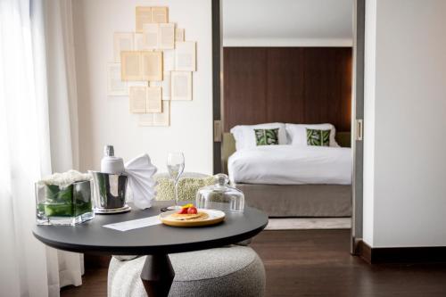 a small table in a room with a bed at Le Louise Hotel Brussels - MGallery Collection in Brussels