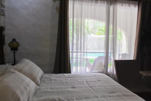 una camera da letto con un letto e una grande finestra di Hotel Boutique Canto De Piedra a Tamasopo