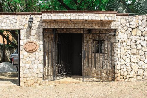 a stone building with a door with a gate at Hotel Boutique Canto De Piedra in Tamasopo