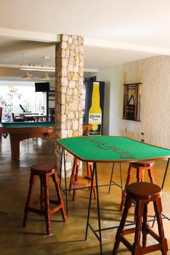 a ping pong table in a room with two stools at Hotel Boutique Canto De Piedra in Tamasopo
