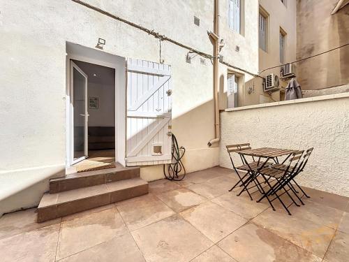 un patio avec une table et des chaises à côté d'un bâtiment dans l'établissement Appartement High Standing - Jardin & Climatisation - Les Frères de la Loc', à Marseille