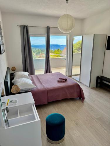 a bedroom with a bed and a large window at Apartments ŽAJA in Seget Vranjica
