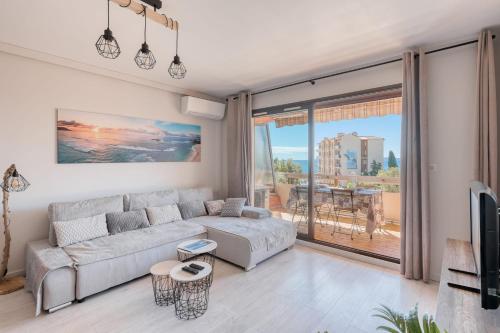 a living room with a couch and a tv at Le Diamant du Soleil Sea View New City Center & Parking in Le Lavandou