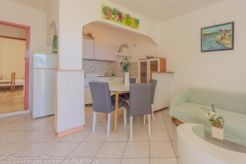 a kitchen and living room with a table and chairs at Galeb in Kustići