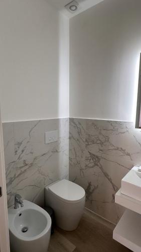 a bathroom with a white toilet and a sink at Rosso Conero - Le Grotte Rooms & Apartments in Camerano