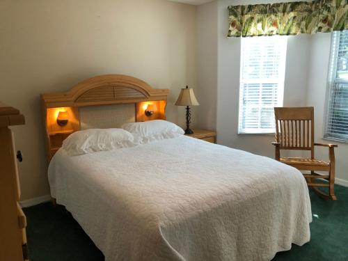 a bedroom with a large white bed and a chair at 119 Z2b VILLAGE LA ZAMORA by REMAX Premier in The Villages