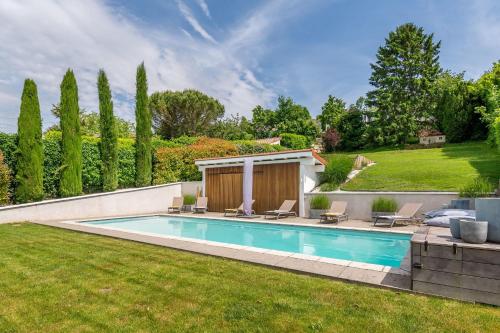 une piscine dans une cour avec des chaises autour dans l'établissement La Radieuse, à Saint-Didier-au-Mont-dʼOr