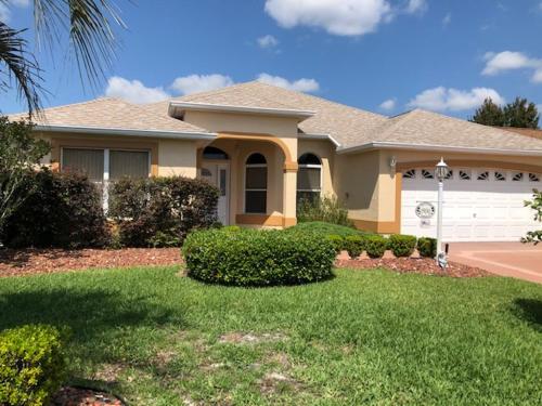 a large house with a yard with a driveway at 1506 Z2b VILLAGE OF SANTO DOMINGO by REMAX Premier in The Villages