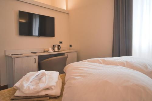 a hotel room with a bed and a flat screen tv at Villa Nicolli Romantic Spa Resort - Adults Only in Riva del Garda