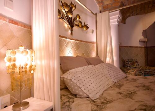 una camera con letto a baldacchino e lampada di Melegis 1-Bed Cottage Sleeps 2 Pool & Garden a Melegis