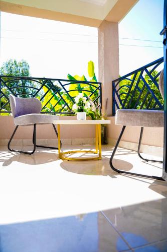 a living room with two chairs and a table at Haven Suites Bnb - Runogone in Meru