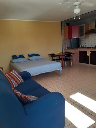 a bedroom with a bed and a couch and a kitchen at Contrada Vento home sharing in Campomarino