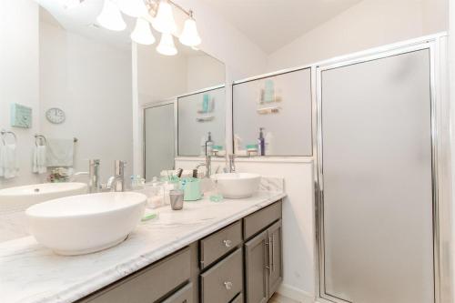 Un baño blanco con dos lavabos y una ducha. en 2332 Z3B VILLAGE OF HADLEY by REMAX Premier, en The Villages
