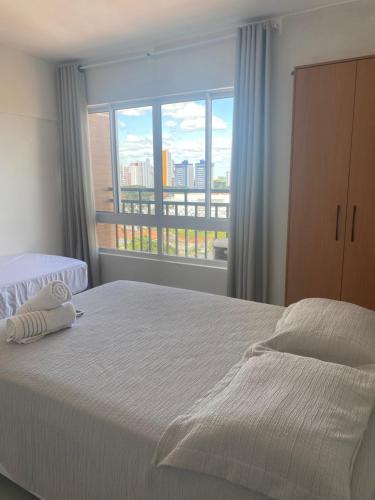 a bedroom with a large bed and a large window at Apartamento Estúdio in Teresina