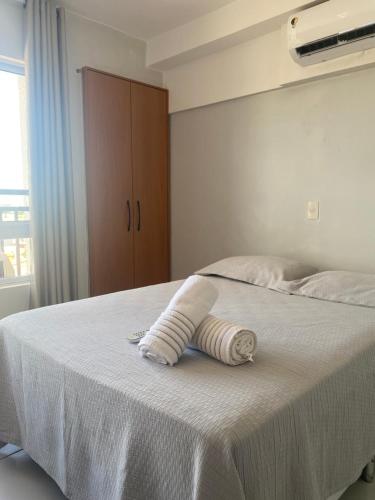 a white bed with a towel on top of it at Apartamento Estúdio in Teresina