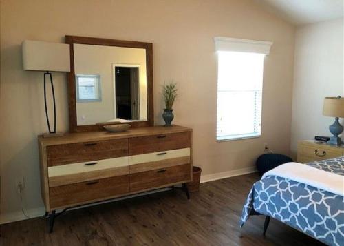 a bedroom with a dresser with a mirror and a bed at 2474 Z3a VILLAGE OF ST JAMES by REMAX Premier in The Villages