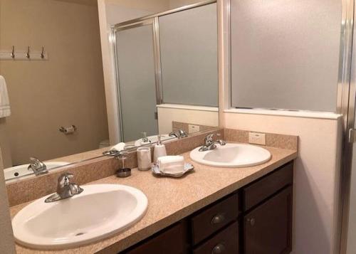 a bathroom with two sinks and a large mirror at 2474 Z3a VILLAGE OF ST JAMES by REMAX Premier in The Villages