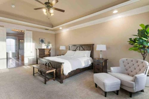 une chambre avec un grand lit et une chaise dans l'établissement Luxe Retreat: Pool, Spa,Jacuzzi, EV Charger & more, à DeCordova