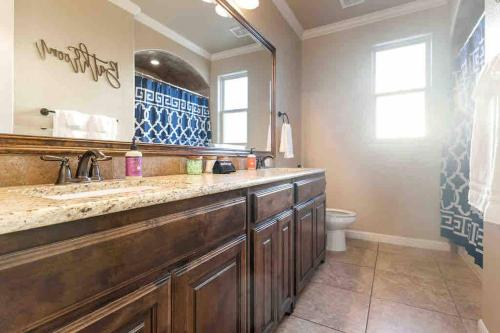La salle de bains est pourvue d'un grand lavabo et de toilettes. dans l'établissement Luxe Retreat: Pool, Spa,Jacuzzi, EV Charger & more, à DeCordova