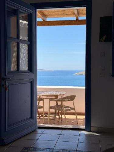 an open door to a patio with a table on the beach at Lipsi Blue Hotel in Lipsoi