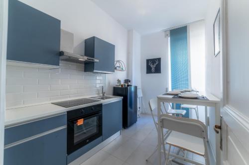 a small kitchen with blue cabinets and a stove at Elegant Apartments Palumbo in Rome