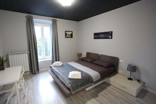 a bedroom with a bed and a desk and a window at New Ulivo Apartment 2 in Seriate