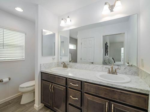 a bathroom with two sinks and a toilet at 5049 Z6 VILLAGE OF MARSH BEND by REMAX Premier in The Villages