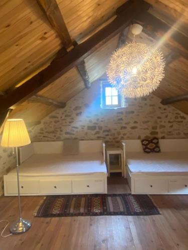une pièce avec deux bancs et un lustre dans un grenier dans l'établissement Dourbias, Rural home in stunning setting, à Nant