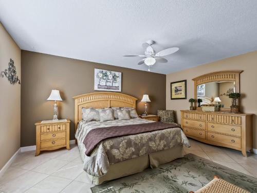 a bedroom with a bed and two dressers and a fan at 3496 Z2A VILLAGE OF SUMMERHILL by REMAX Premier in The Villages