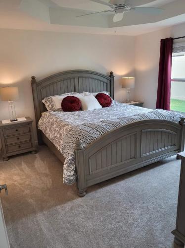 a bedroom with a large bed with red pillows at 5991 Z5 VILLAGE OF ST. CATHERINE by REMAX Premier in The Villages