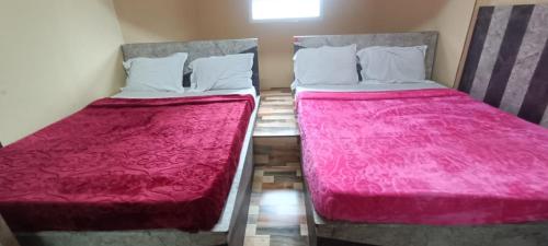 two beds sitting next to each other in a room at HOTEL SHIV SHANTHI INN MOORTHI HOSPITALITY OOTy in Ooty