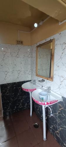a bathroom with a sink and a mirror at HOTEL SHIV SHANTHI INN MOORTHI HOSPITALITY OOTy in Ooty