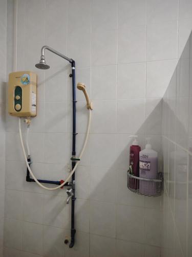 a shower in a bathroom with a soap dispenser at 22 Homestay Tenom in Tenom