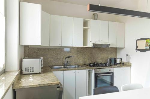 a kitchen with white cabinets and a sink at Ca Luigina - 7 min dalla stazione - Wi-fi gratuito in Legnano