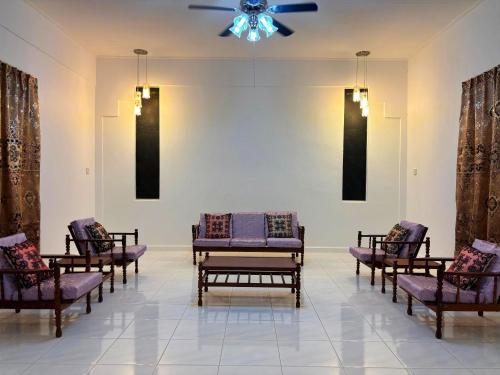 a room with several chairs and a ceiling fan at 22 Homestay Tenom in Tenom