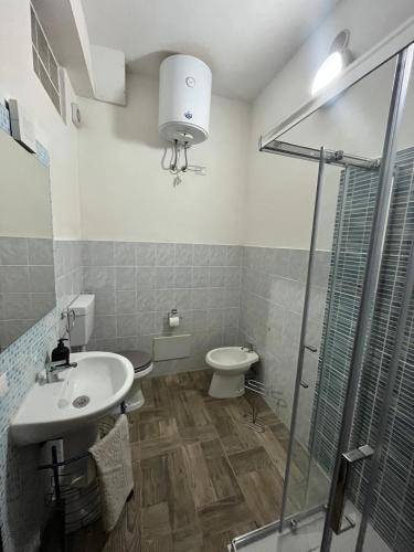 a bathroom with a toilet and a sink and a shower at Casa Giuli in Villasimius