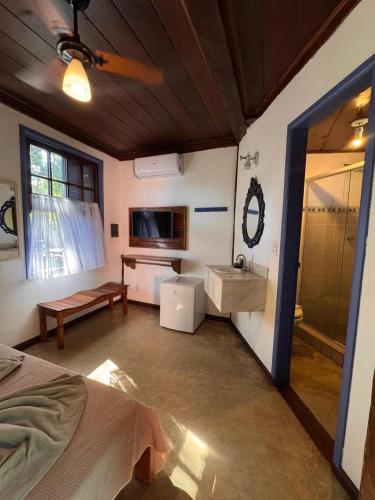 a room with a bed and a bathroom with a sink at Vila Pequeá Pousada Ilhabela in Ilhabela