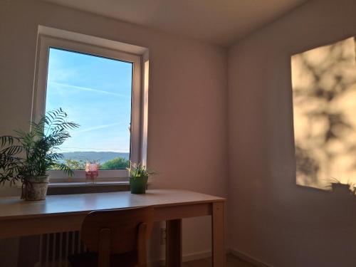 a room with a table and a window with plants at Neu renovierte Wohnung mit Traumaussicht & Natur pur in Schnabelwaid