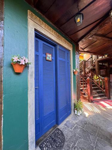 a blue door on the side of a building at Vila Pequeá Pousada Ilhabela in Ilhabela