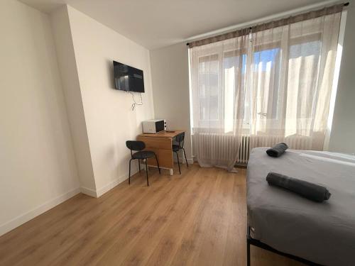 une chambre avec un lit, un bureau et une fenêtre dans l'établissement M28 Marquer joli appartement proche de la gare et du centre ville, à Annemasse