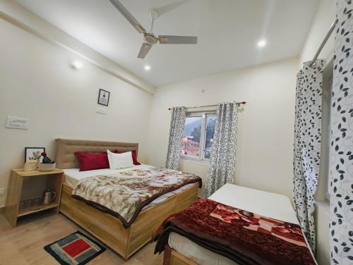 a bedroom with two beds and a window at Ganga Kinaare in Uttarkāshi
