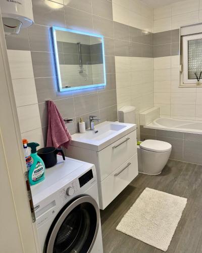 a bathroom with a washing machine and a sink at Apartments ŽAJA in Seget Vranjica