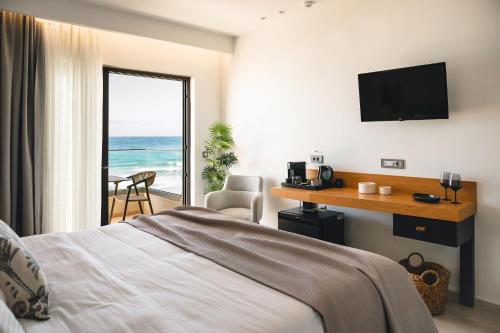 sypialnia z łóżkiem i widokiem na ocean w obiekcie Batis Beach Hotel w Retimnie