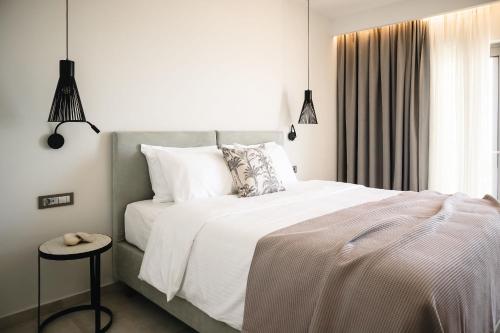 a bedroom with a white bed and a window at Batis Beach Hotel in Rethymno Town