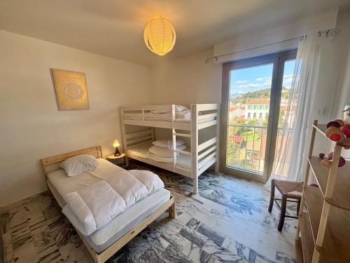une chambre avec un lit et une grande fenêtre dans l'établissement Grand T3 tout équipé au cœur du village, à Saint-Mandrier-sur-Mer